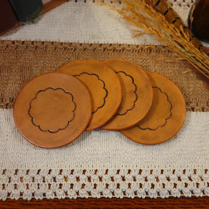 Set of round handmade leather coasters with a simple flower design