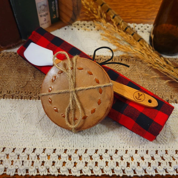 western gift set with handmade (light buckstitch) leather coasters, white mini-spatula, and red/black plaid towel