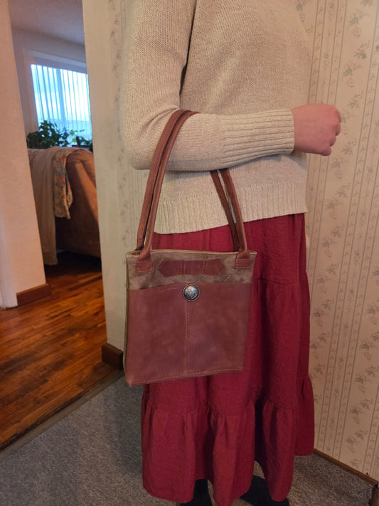 brown handmade leather handbag held on a woman's arm
