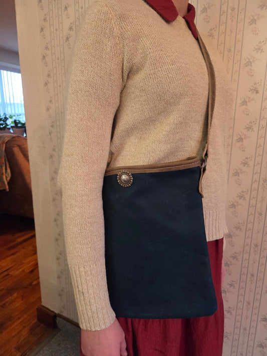 dark blue handmade crossbody leather purse being worn by a woman
