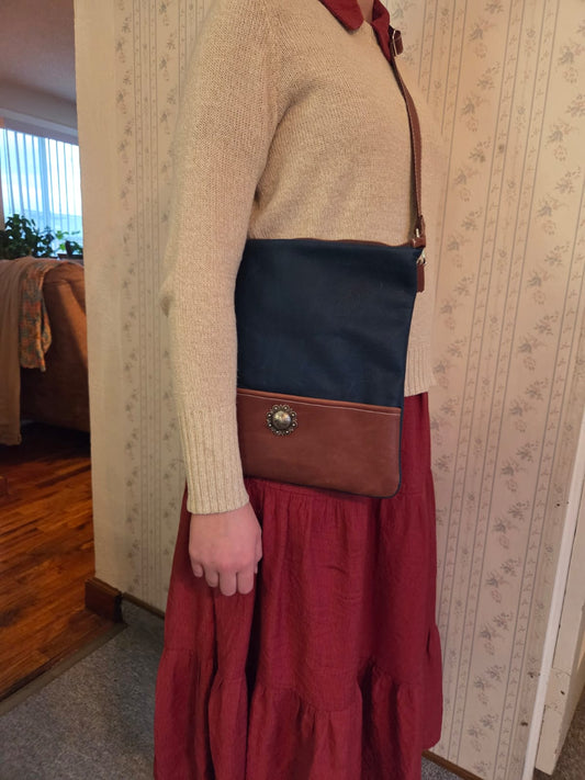 dark blue handmade crossbody leather purse being worn by a woman